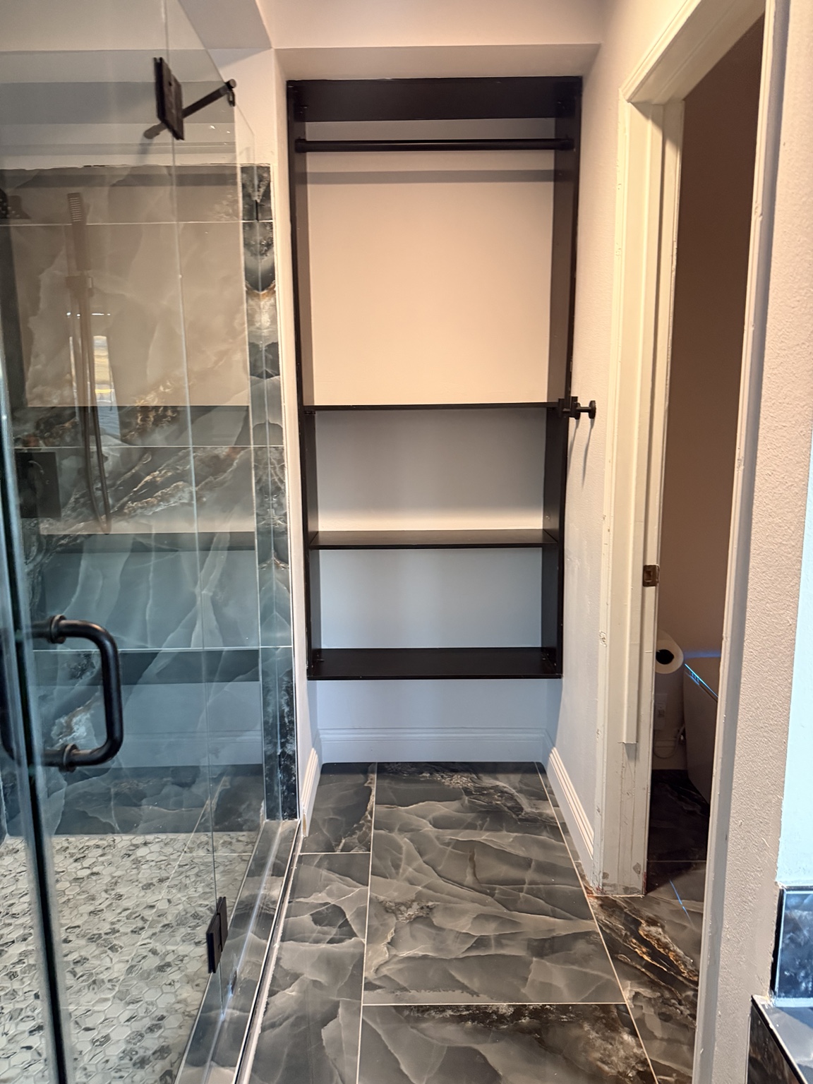 Bathroom built-in storage beside glass shower